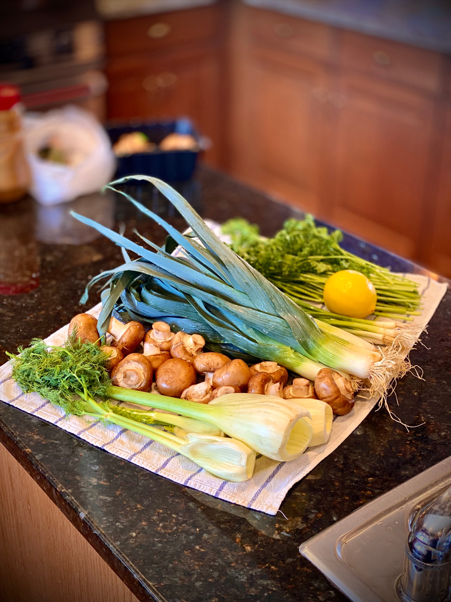 Fresh market produce — leeks, mushrooms, fennel, and herbs